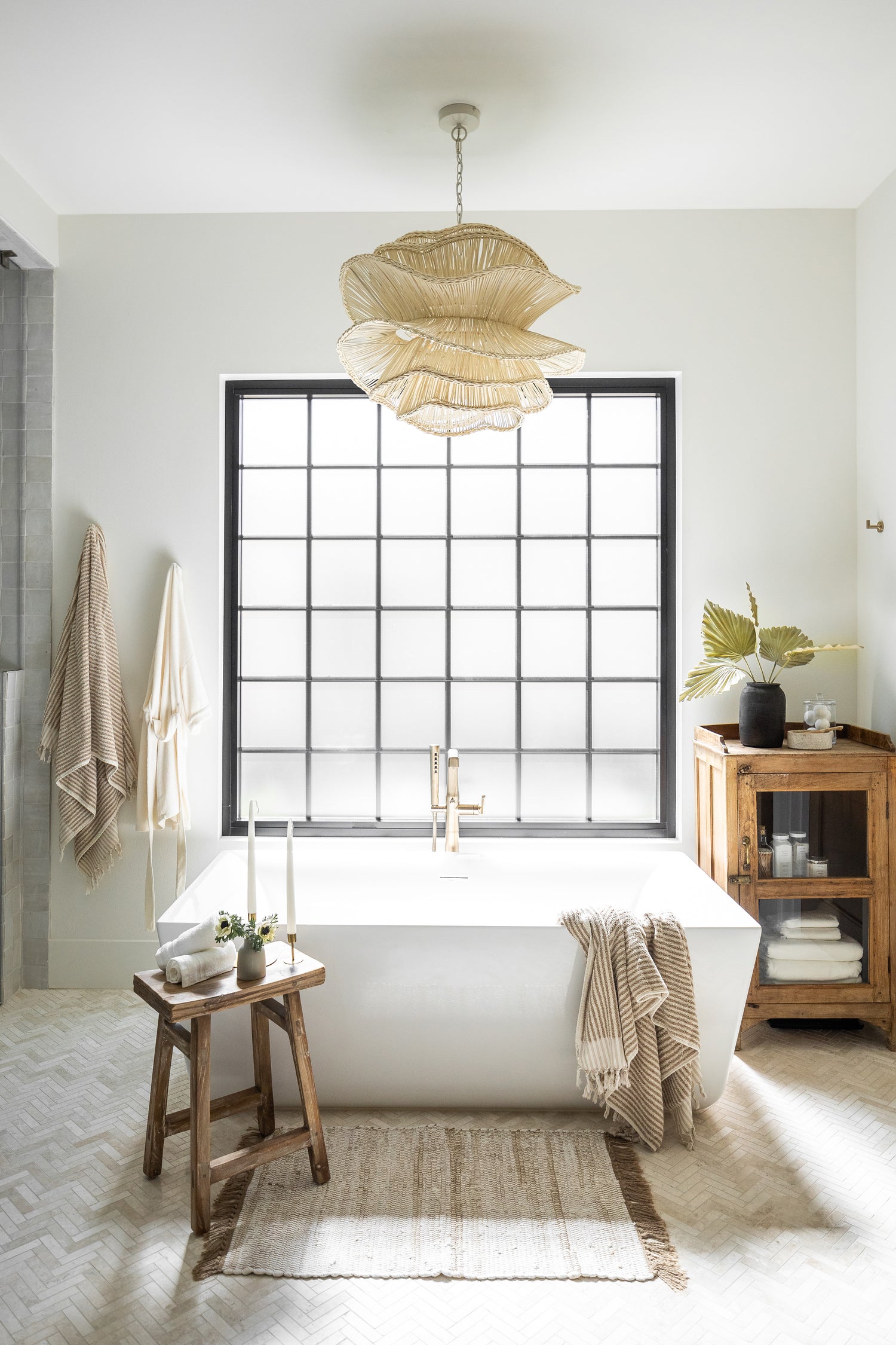 Free standing tub surrounded by decor with an organic shaped pendant light hanging above - View our lighting guide