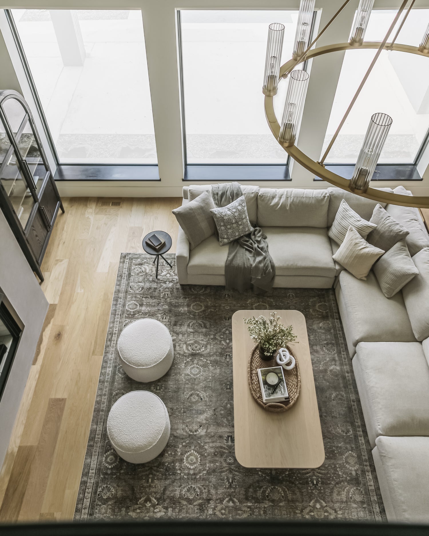 Top-down view of a living room featuring a neutral, patterned rug  - View our rug selection and placement guide